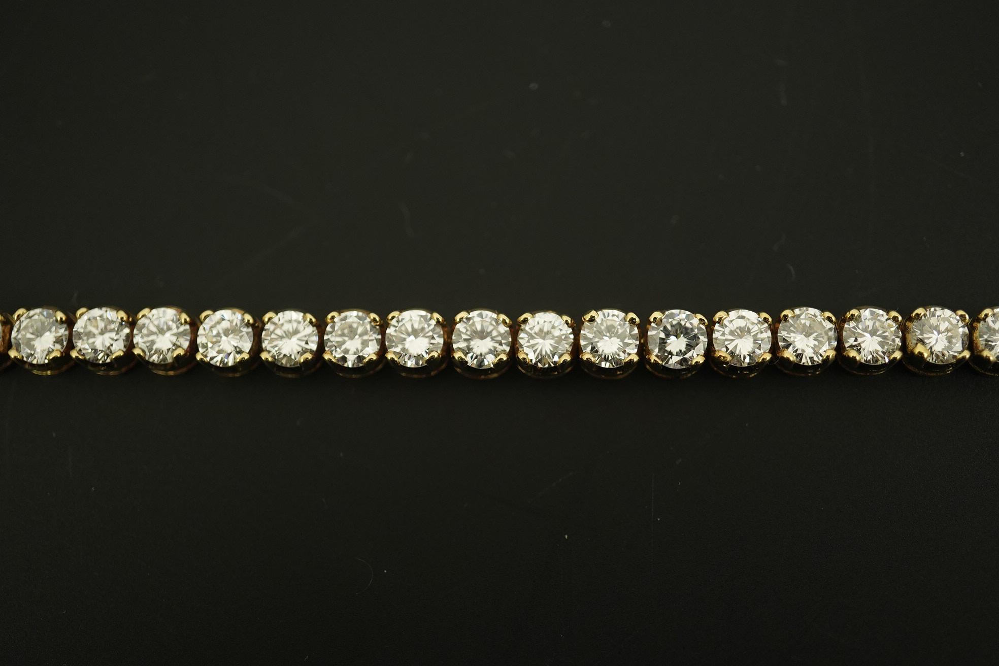 A modern 14k gold and thirty five stone round brilliant cut diamond set tennis bracelet